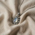 Shiny Moonstone Necklace with Teardrop Pendant and Silver Floral Motifs