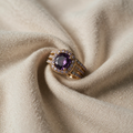 Gold-coloured Ring with purple centre stone and triple band