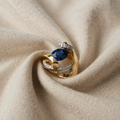 Gold-coloured Ring with oval blue crystal