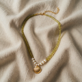 Necklace with shell pendant and green pearls