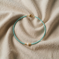 Necklace with turquoise-coloured pearls and pearl effect