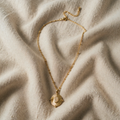 Gold-coloured necklace with rope chain and relief plaque
