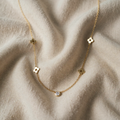 Gold-coloured necklace with floral motifs and crystal